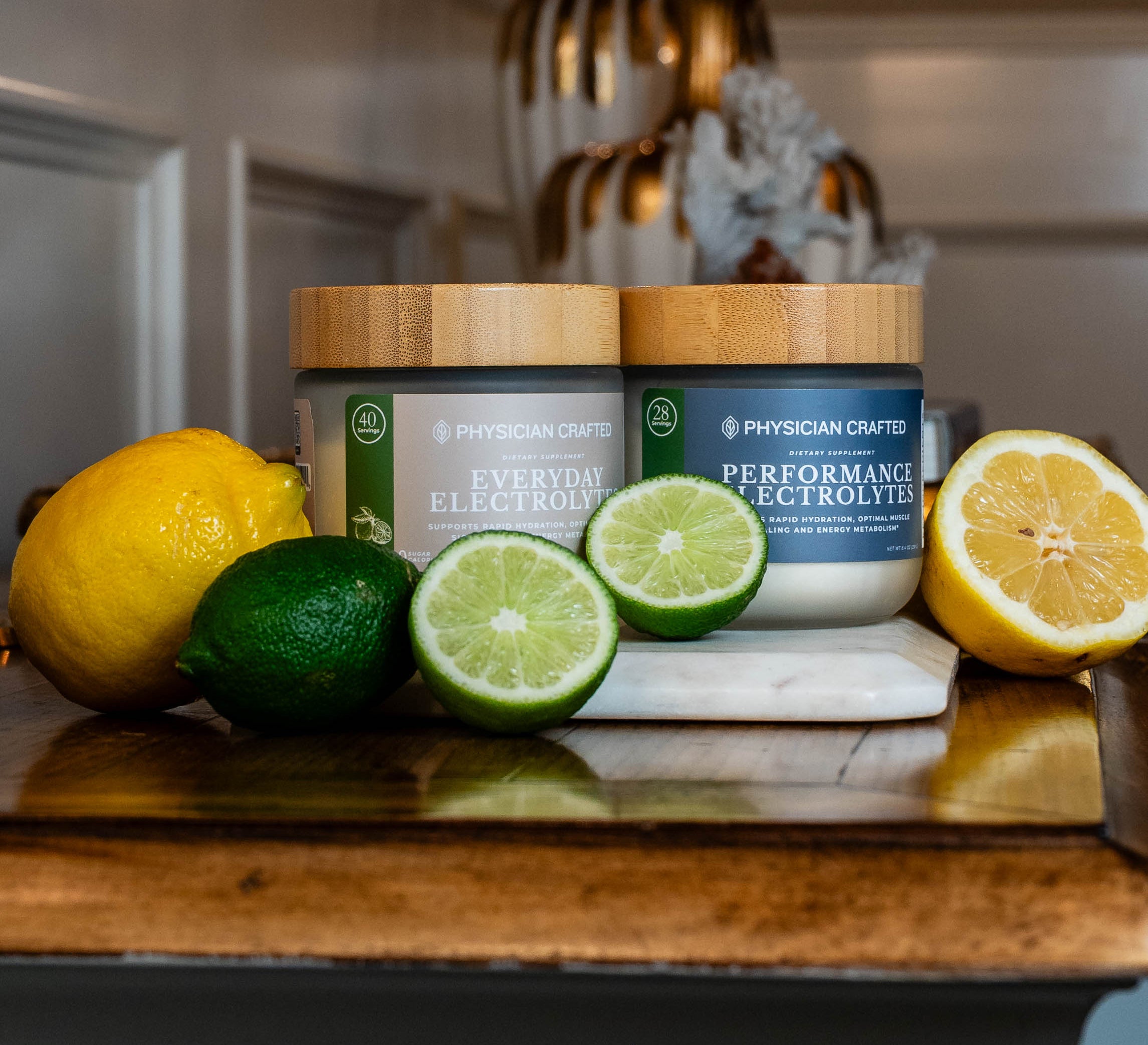 Two jars labeled 'Everyday Electrolytes' and 'Performance Electrolytes' on a kitchen counter with lemons and limes.